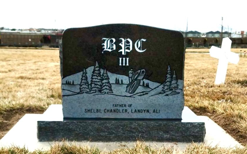 Black granite headstone in a cemetery; 