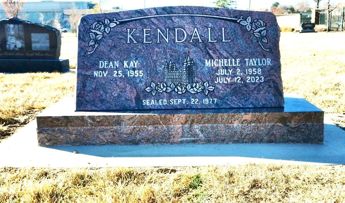 A gravestone for the Kendall family; names, dates, and a carved floral design.