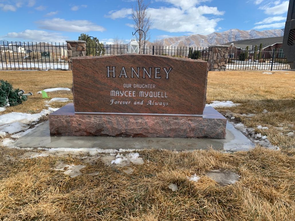 Red granite headstone with the name 