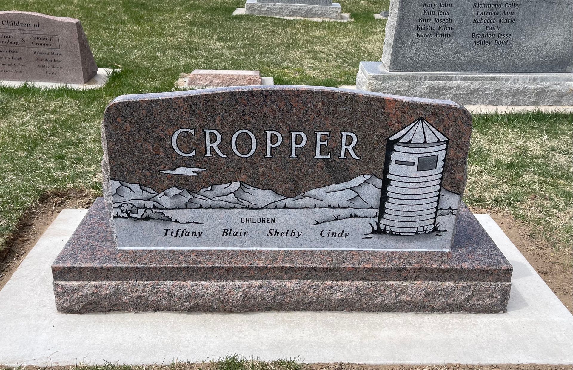 Cropper family headstone in a cemetery, with a water tower engraving.