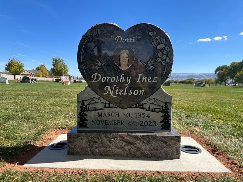 Heart-shaped headstone for Dorothy Inez Dotti Nielson, with birth/death dates, photo, in a cemetery.