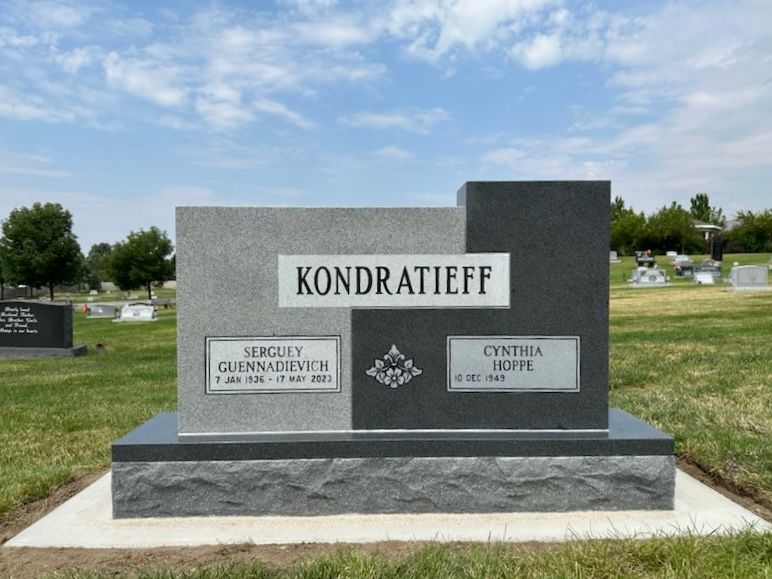 Gray and black tombstone in a cemetery, bearing the name Kondratieff and names of Sergeiy and Cynthia.