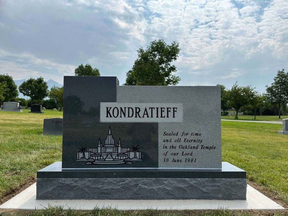 A tombstone at a cemetery. Dark and light granite with Kondratieff and a temple illustration.
