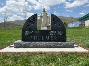 Black granite tombstone with sculpture of Jesus