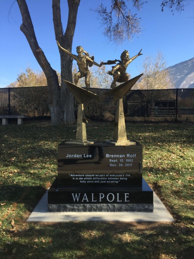 Bronze sculpture of two children atop a tombstone, WALPOLL engraved on the base.