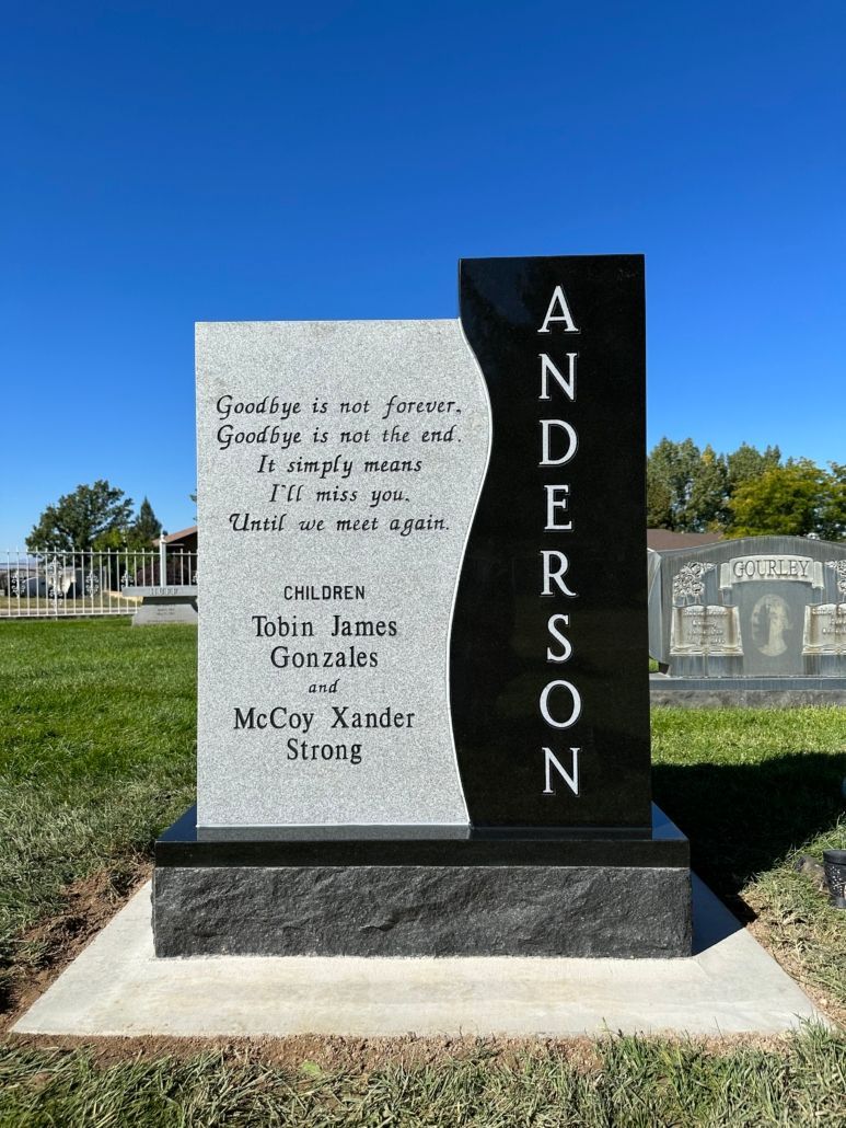 Gray and black tombstone with etched text and the name ANDERSON in white.
