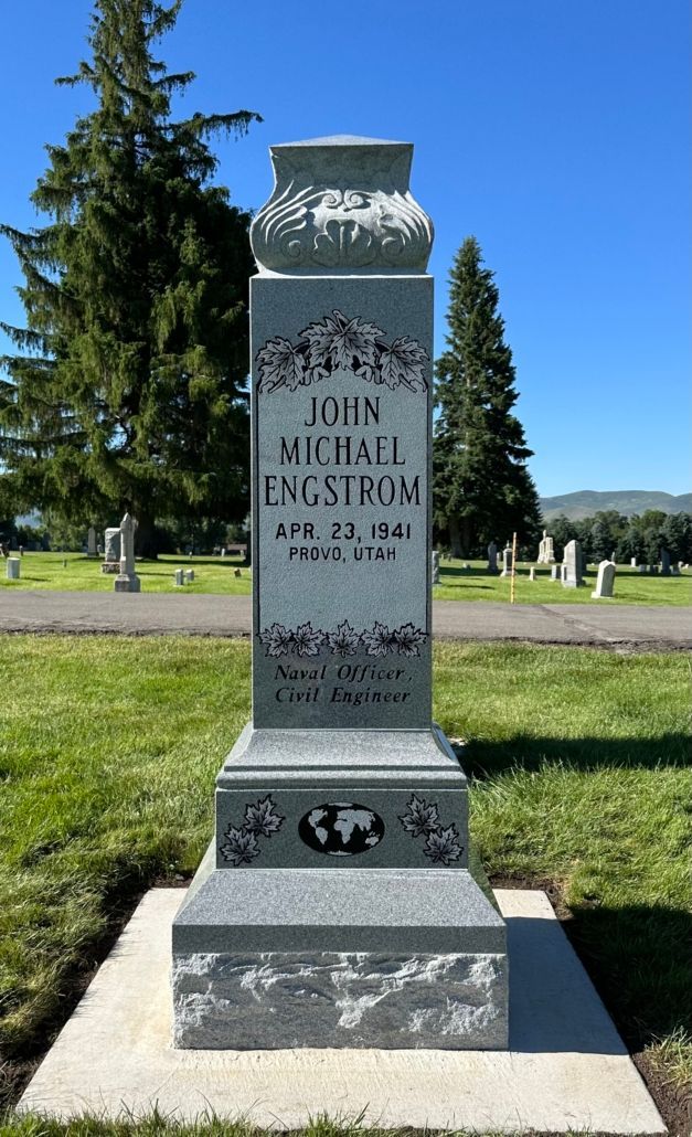 A tall gray headstone in a cemetery