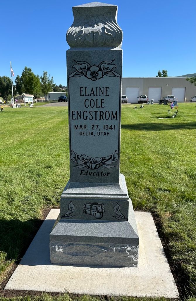 Granite tombstone for Elaine Cole Engstrom, with dates and decorative details, in a cemetery.