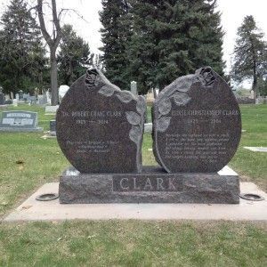 Tombstone split in two with names of Robert and Denise Clark, roses, dates, and epitaphs, in a cemetery.