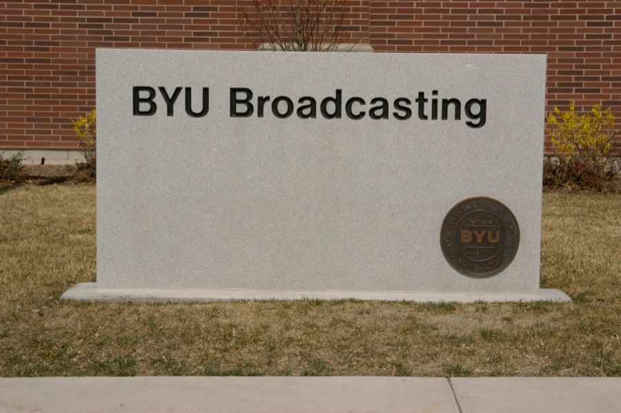BYU Broadcasting sign on a concrete rectangular structure. Black letters on a white background.