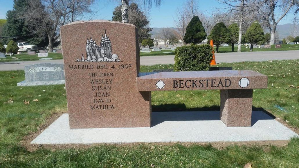 Gravestone with bench; names Beckstead, a reddish-brown stone in a grassy cemetery.