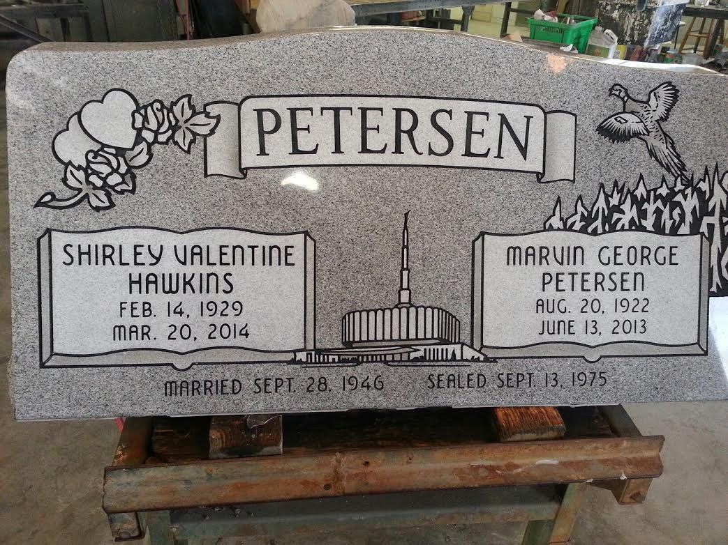 Gray granite headstone with PETERSEN banner; names, birth/death dates, and temple insets.
