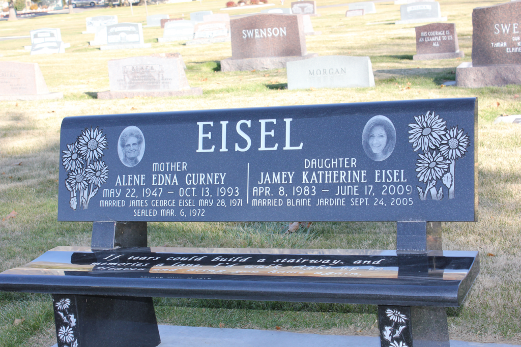 Black granite bench headstone with the name Eisel; photos, names and dates of birth/death. Cemetery.