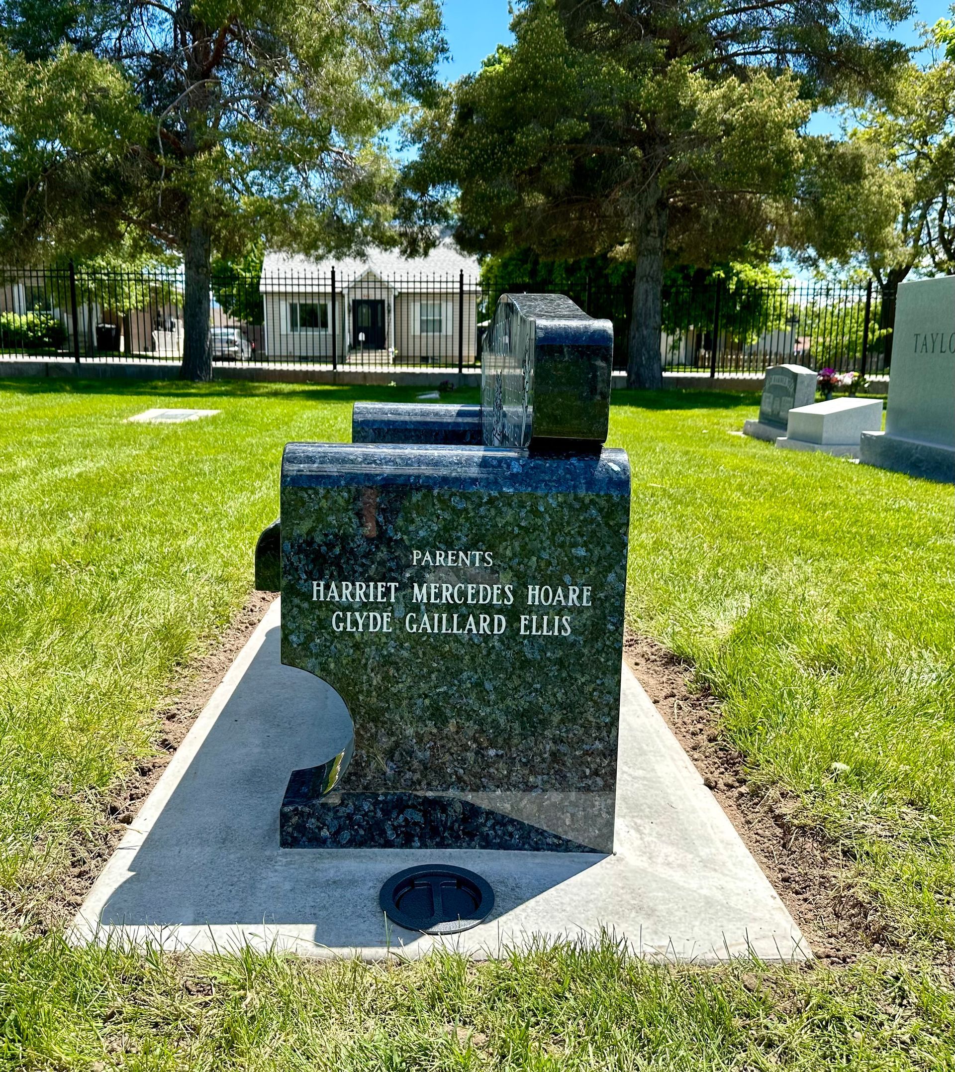Black granite bench-shaped memorial in a cemetery; engraved text and puzzle piece cut-out.