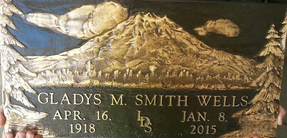 Bronze headstone with mountain scene, Gladys M. Smith Wells, dates 1918-2015.