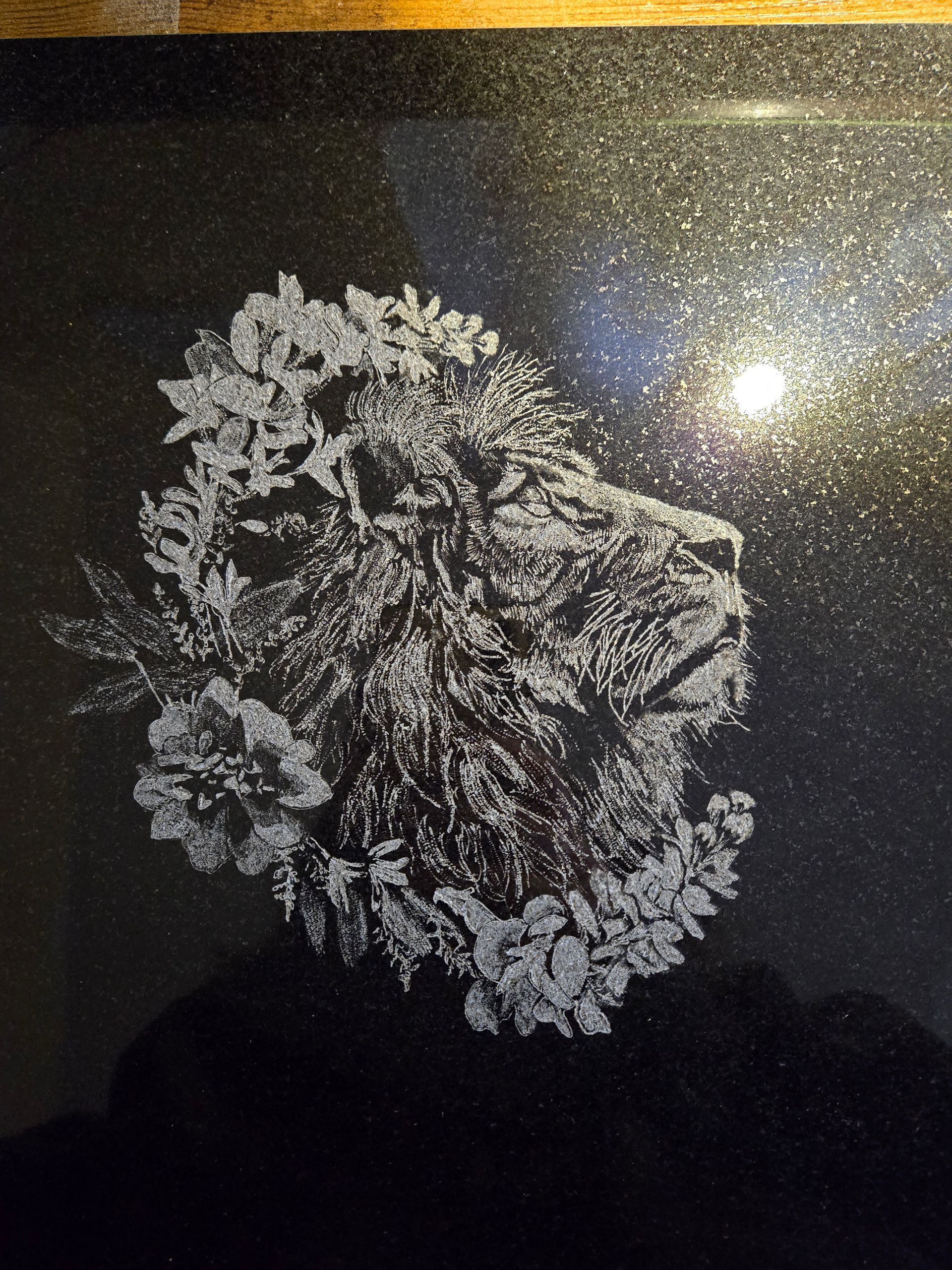 Lion's head profile design made of flowers on a black background.