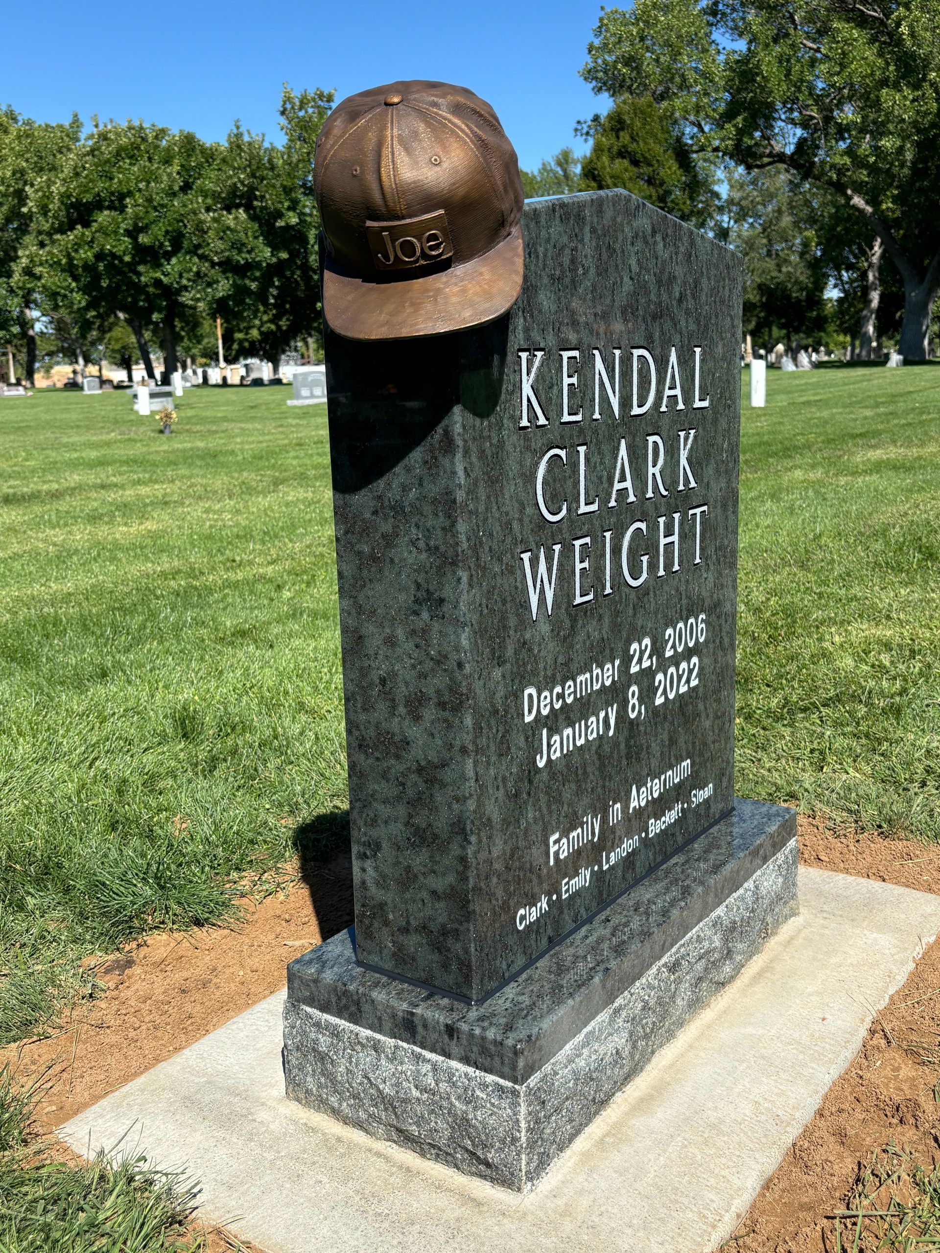 Gravestone of Kendal Clark Wright with a baseball cap on top.