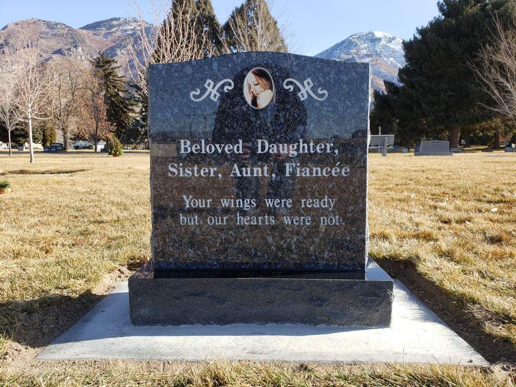 Headstone in a cemetery. Dark granite with a photo