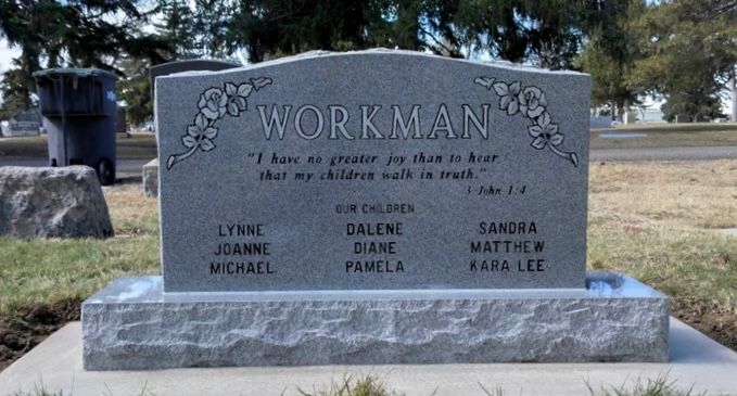 Gray headstone with the name WORKMAN and names of family members in a cemetery.