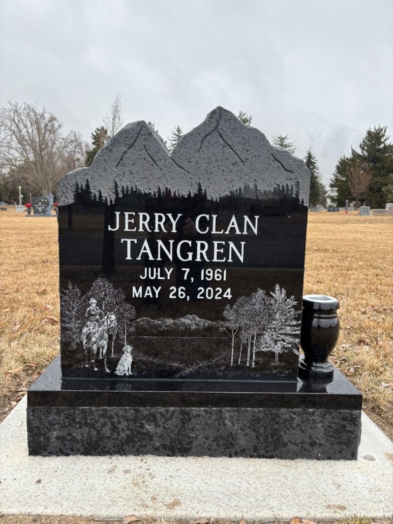Black granite tombstone with name Jerry Clan Tangren, birth/death dates, mountain and scene engraving, and a vase.