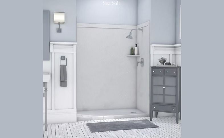 A modern bathroom with a white shower stall, gray accents, and a gray rug.