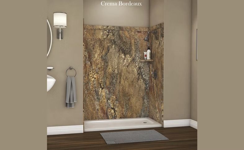 Bathroom with a walk-in shower featuring a marbled beige and brown wall design, white basin, and light fixtures.