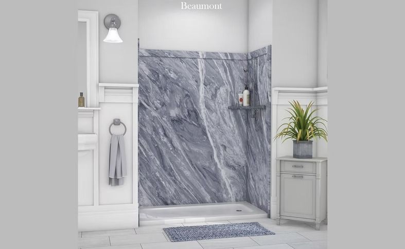 Bathroom with a gray marble shower surround, white trim, and a small gray cabinet. A blue bath mat sits on the floor.