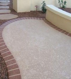 A patio with a brick walkway and a bench.