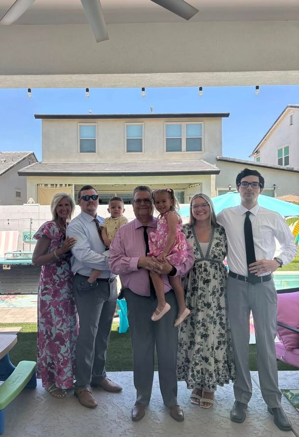 A group of people are posing for a picture in front of a house.
