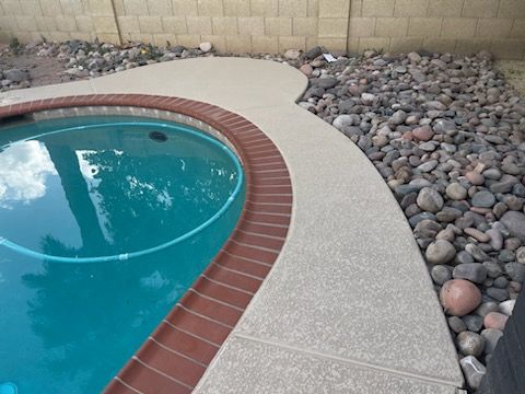 A swimming pool surrounded by rocks and a brick walkway