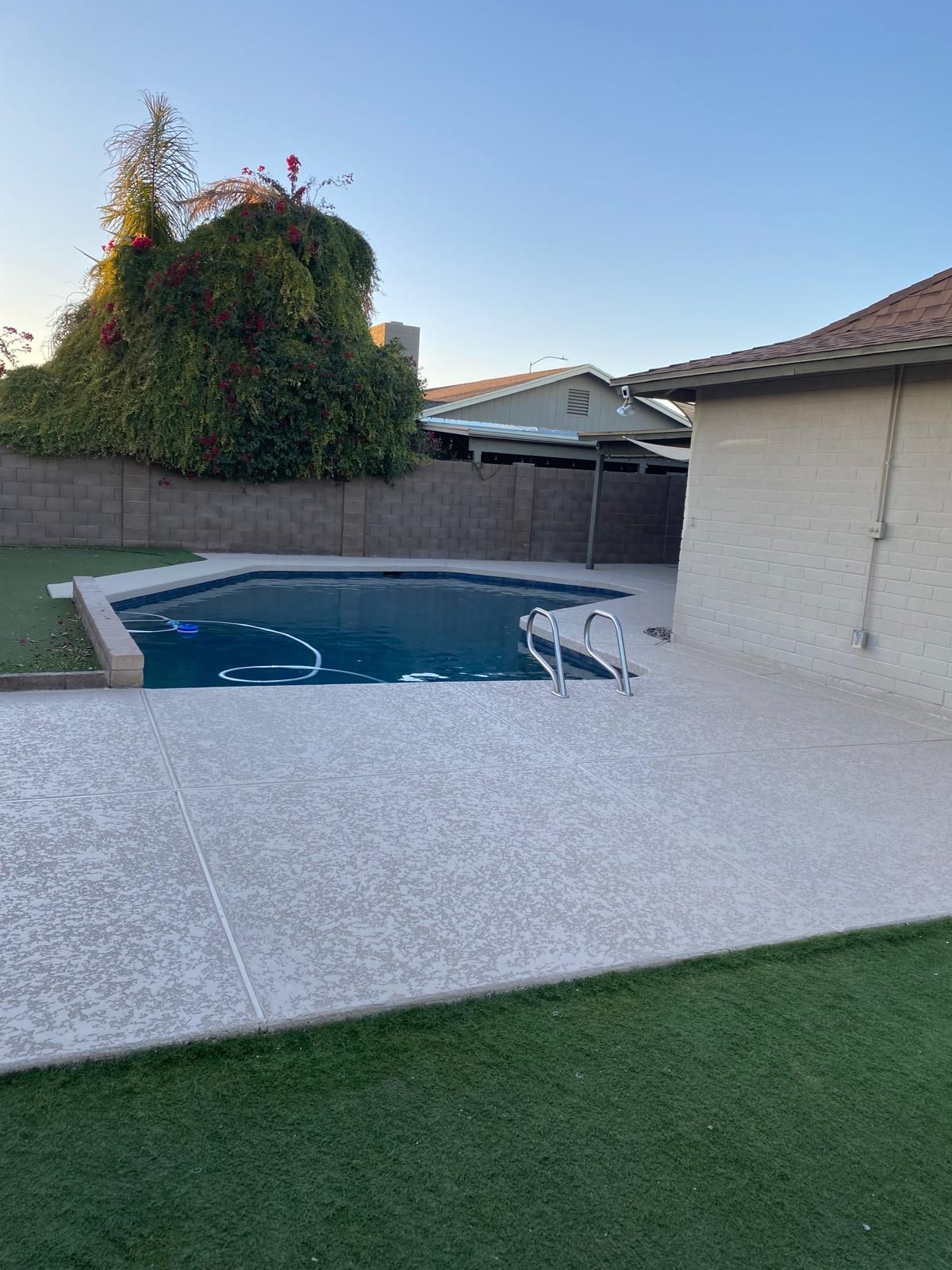 There is a swimming pool in the backyard of a house.