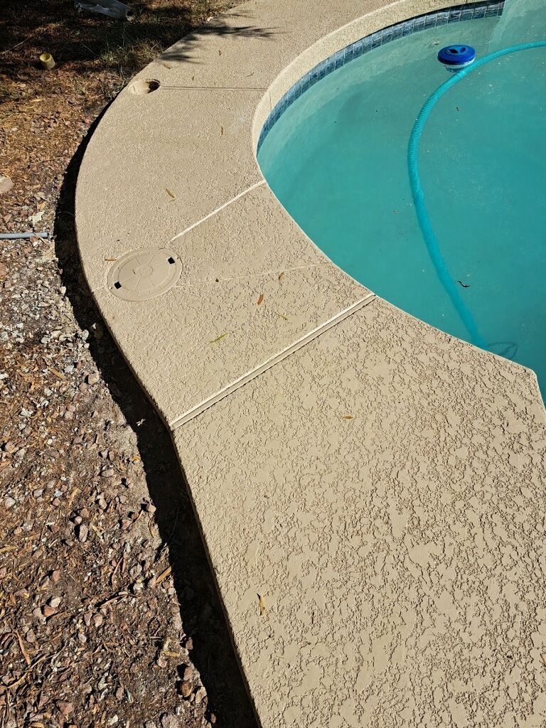 A swimming pool with a hose attached to the edge of it
