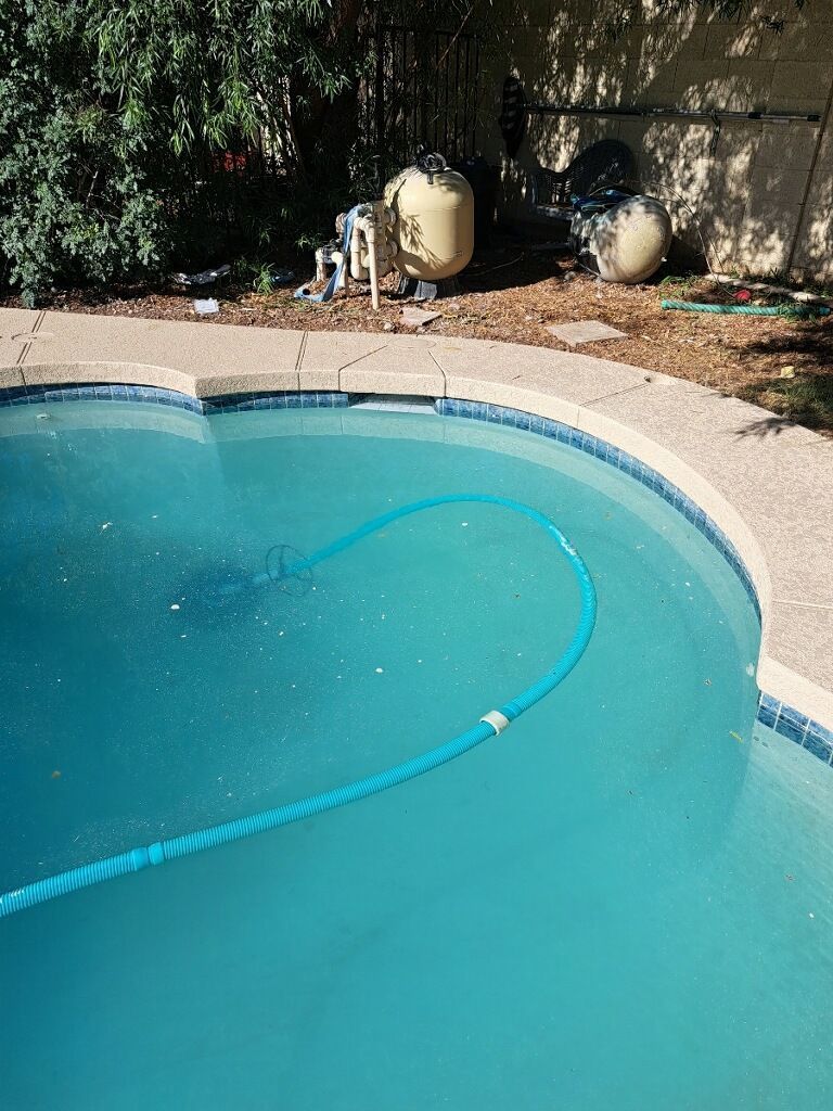 A swimming pool with a hose in the middle of it.
