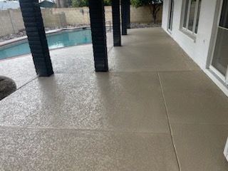 A patio with a swimming pool in the background