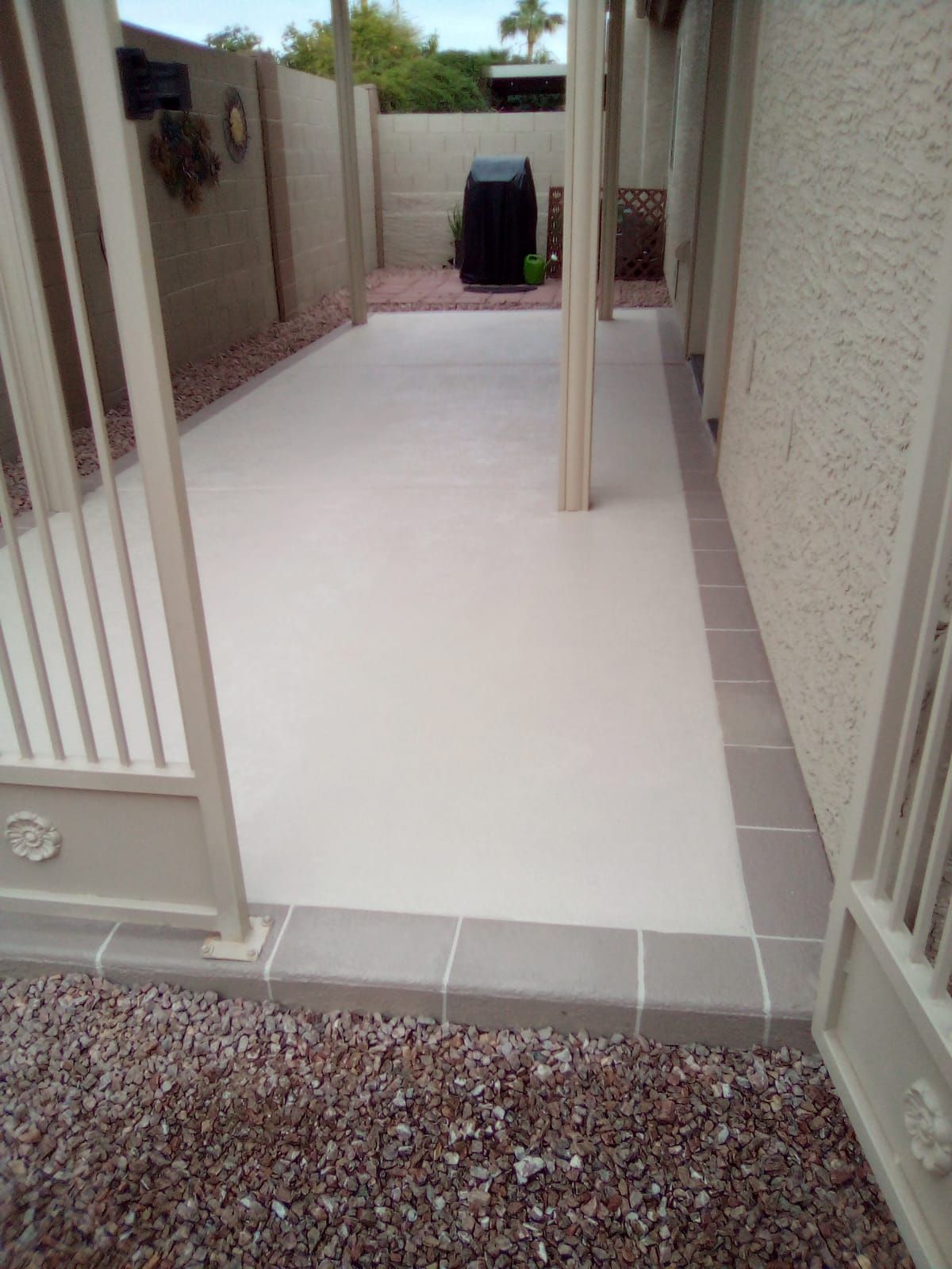A patio with a fence and a white tile floor