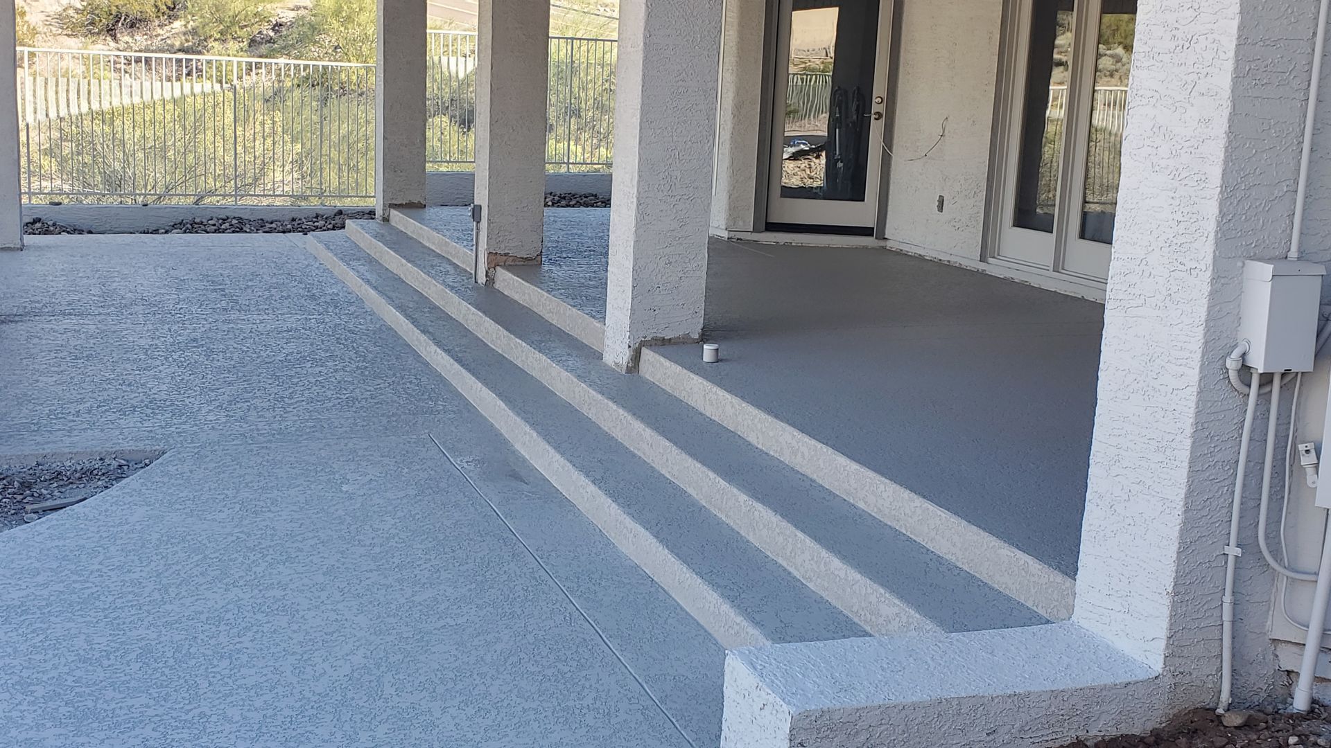 A concrete porch with stairs leading up to it