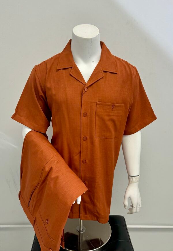 A mannequin is wearing an orange shirt and pants