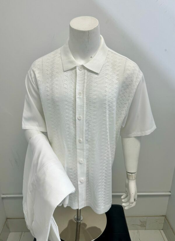 A mannequin is wearing a white shirt and a white jacket.