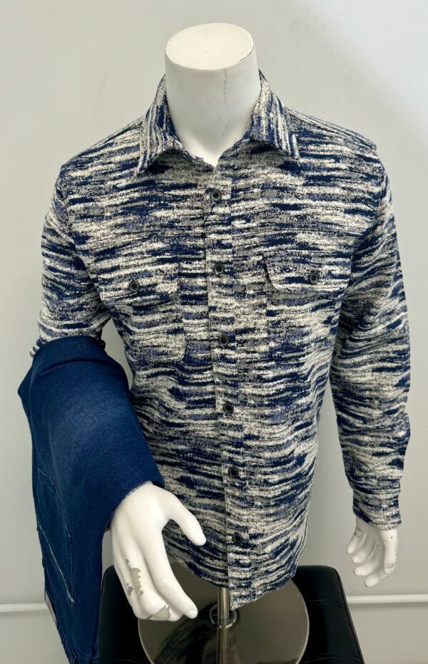 A mannequin is wearing a blue and white shirt and a blue scarf.