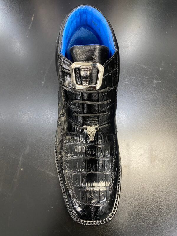 A close up of a black shoe with a blue lining on a table.