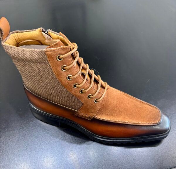 A pair of brown lace up boots on a black surface