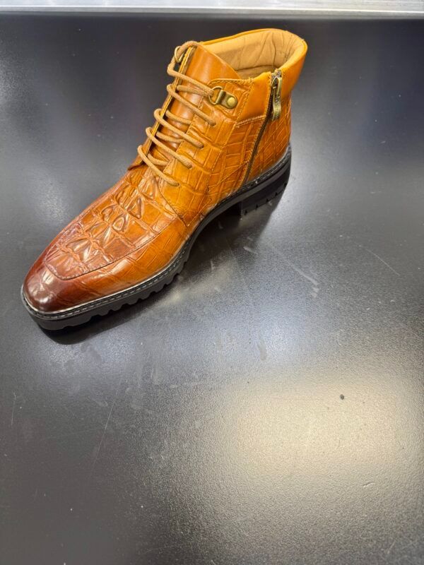 A pair of brown boots is sitting on a black table.