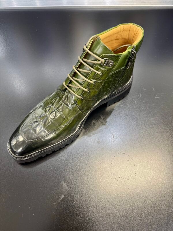 A green boot is sitting on top of a black table.