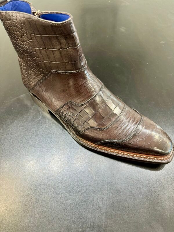 A pair of brown leather boots are sitting on a black table.