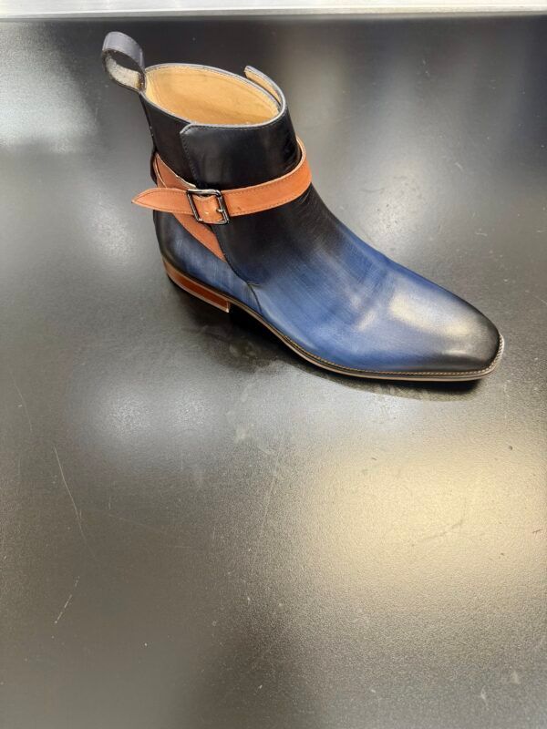 A pair of blue and brown boots are sitting on a black surface.