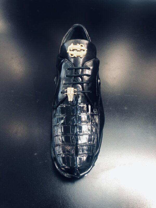 A pair of black shoes with a gold emblem on the side