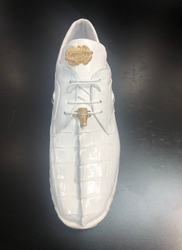 A pair of white shoes with a gold buckle on the side