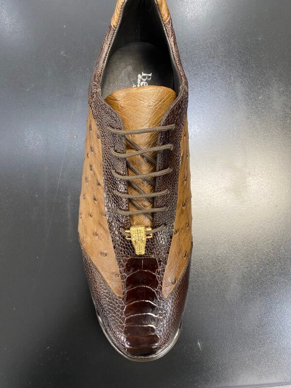 A pair of brown and tan shoes are sitting on a black table.