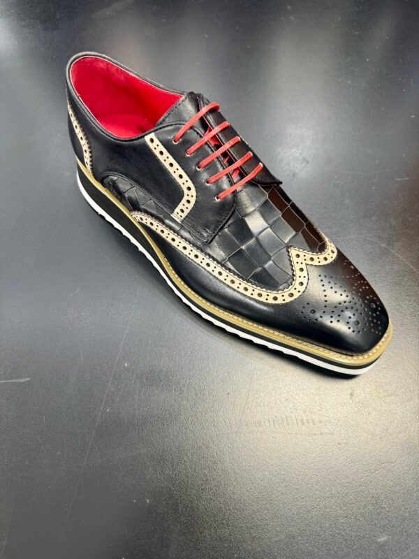 A pair of black shoes with red laces on a black surface