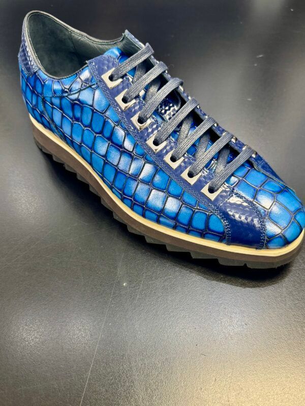 A pair of blue shoes with white laces on a black surface.